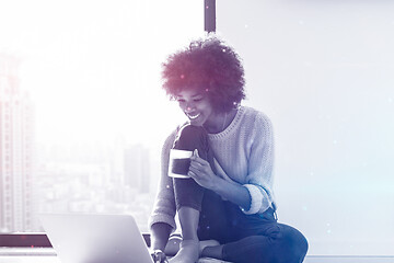 Image showing black woman in the living room on the floor