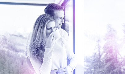 Image showing young couple enjoying morning coffee by the window