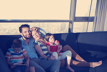 Image showing happy young couple spending time with kids at home