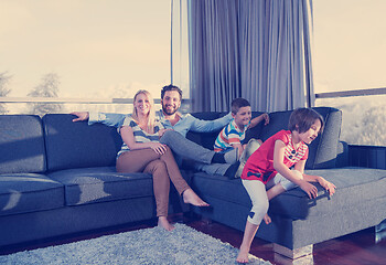 Image showing happy young couple spending time with kids at home