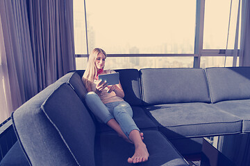 Image showing young woman on sofa at home surfing web