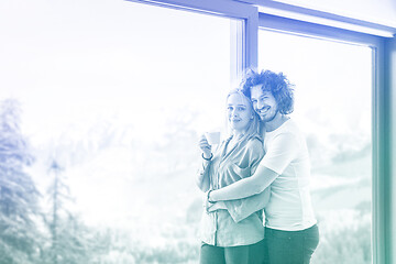 Image showing young couple enjoying morning coffee by the window