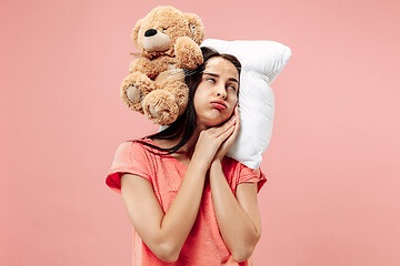 Image showing Tired woman sleeping at home having too much work. Bored businesslady with pillow and toy bear