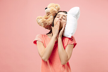 Image showing Tired woman sleeping at home having too much work. Bored businesslady with pillow and toy bear