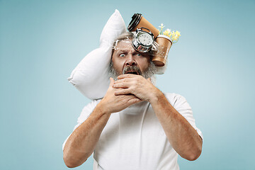 Image showing Tired man sleeping at home having too much work. Bored businessman with pillow and hourglass