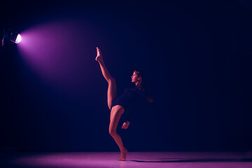 Image showing Young female ballet dancer on neon lights studio background.