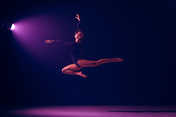 Image showing Young female ballet dancer on neon lights studio background.