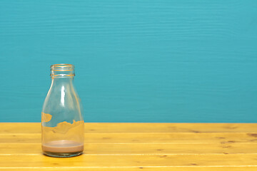 Image showing Glass milk bottle with dregs of chocolate milkshake