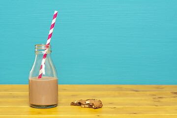 Image showing Straw and bottle half full with milkshake, and half-eaten cookie