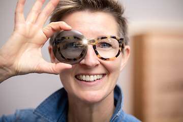 Image showing woman with glasses looking through tinted glass