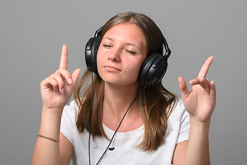 Image showing Portrait of a girl listening to music on headphones