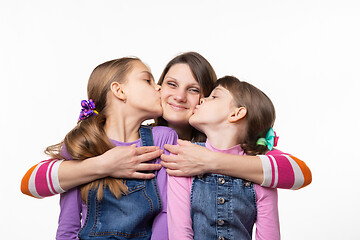 Image showing Children joyfully kiss mom, isolated on white background