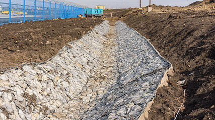 Image showing Gabion and gutter construction along the road