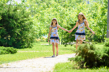 Image showing Two sisters together walk in a beautiful city park