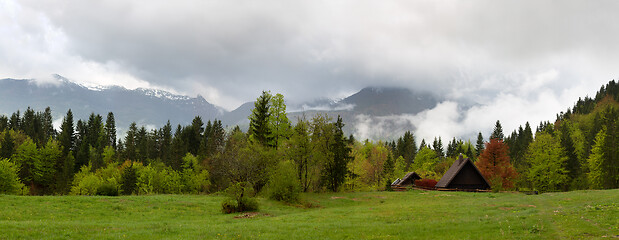 Image showing mountain house in fog clouds at spring