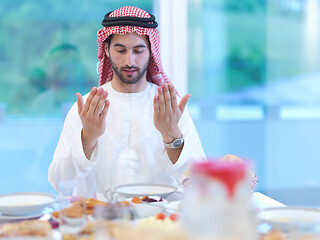 Image showing arabian man making traditional prayer to God before iftar dinner