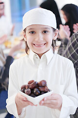 Image showing little muslim boy holding a plate full of sweet dates