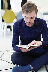 Image showing young muslim man reading Quran at home