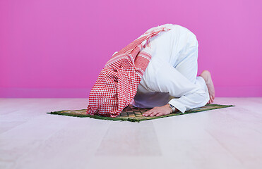 Image showing young arabian muslim man praying on the floor at home