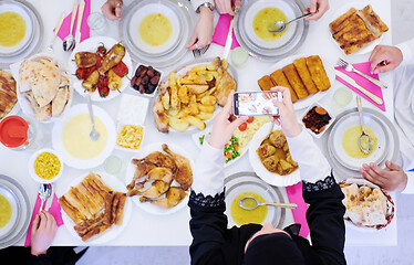 Image showing Muslim family having Iftar dinner taking pictures with mobile ph