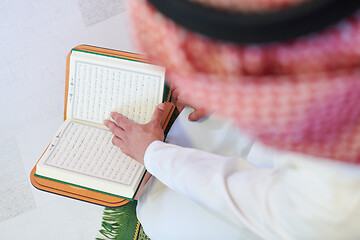 Image showing arabian muslim man reading Quran at home