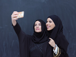 Image showing muslim women taking selfie picture in front of black chalkboard