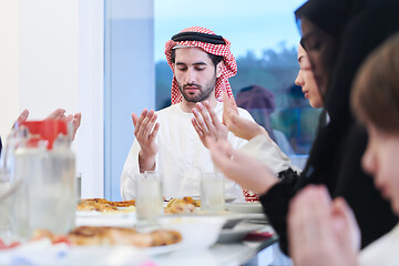 Image showing traditional muslim family praying before iftar dinner