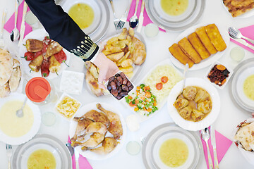 Image showing Muslim family having Iftar dinner eating dates to break feast to