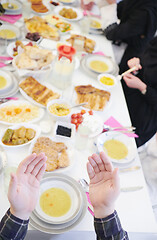 Image showing traditional muslim family praying before iftar dinner