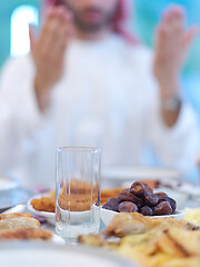 Image showing arabian man making traditional prayer to God before iftar dinner