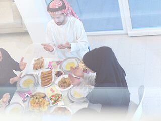 Image showing traditional muslim family praying before iftar dinner