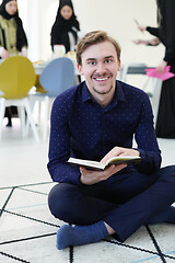 Image showing young muslim man reading Quran at home