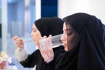 Image showing Muslim family having Iftar dinner drinking water to break feast