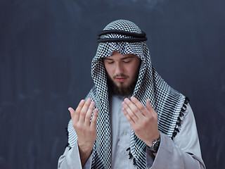 Image showing arabian man making traditional prayer to God, keeps hands in pra