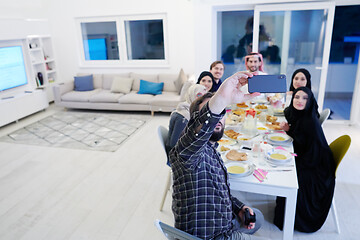 Image showing Muslim family having Iftar dinner taking pictures with mobile ph