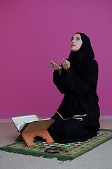 Image showing Middle eastern woman praying and reading the holy Quran