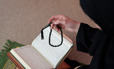 Image showing Middle eastern woman praying and reading the holy Quran