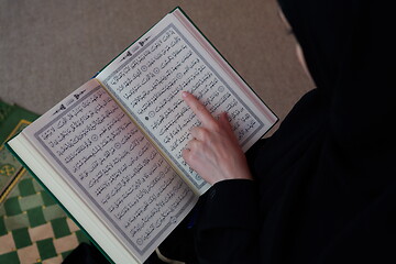 Image showing Middle eastern woman praying and reading the holy Quran