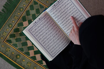 Image showing Middle eastern woman praying and reading the holy Quran