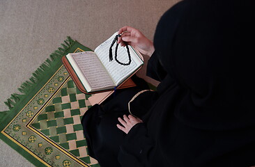 Image showing Middle eastern woman praying and reading the holy Quran