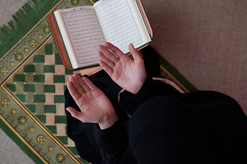 Image showing Middle eastern woman praying and reading the holy Quran