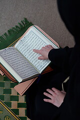 Image showing Middle eastern woman praying and reading the holy Quran