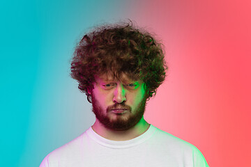 Image showing Caucasian young man\'s portrait on gradient studio background in neon