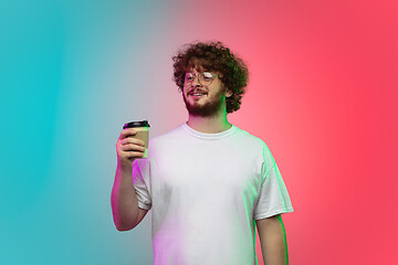 Image showing Caucasian young man\'s portrait on gradient studio background in neon