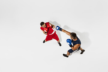 Image showing Two professional boxers boxing isolated on white studio background, action, top view