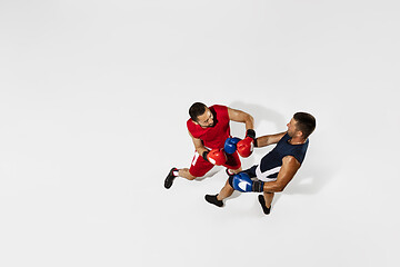 Image showing Two professional boxers boxing isolated on white studio background, action, top view