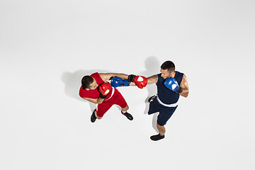 Image showing Two professional boxers boxing isolated on white studio background, action, top view