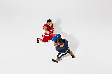 Image showing Two professional boxers boxing isolated on white studio background, action, top view