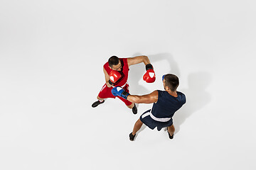 Image showing Two professional boxers boxing isolated on white studio background, action, top view