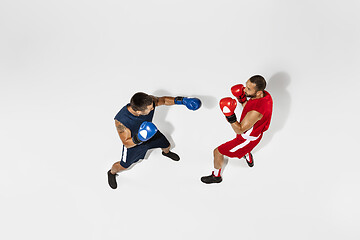 Image showing Two professional boxers boxing isolated on white studio background, action, top view